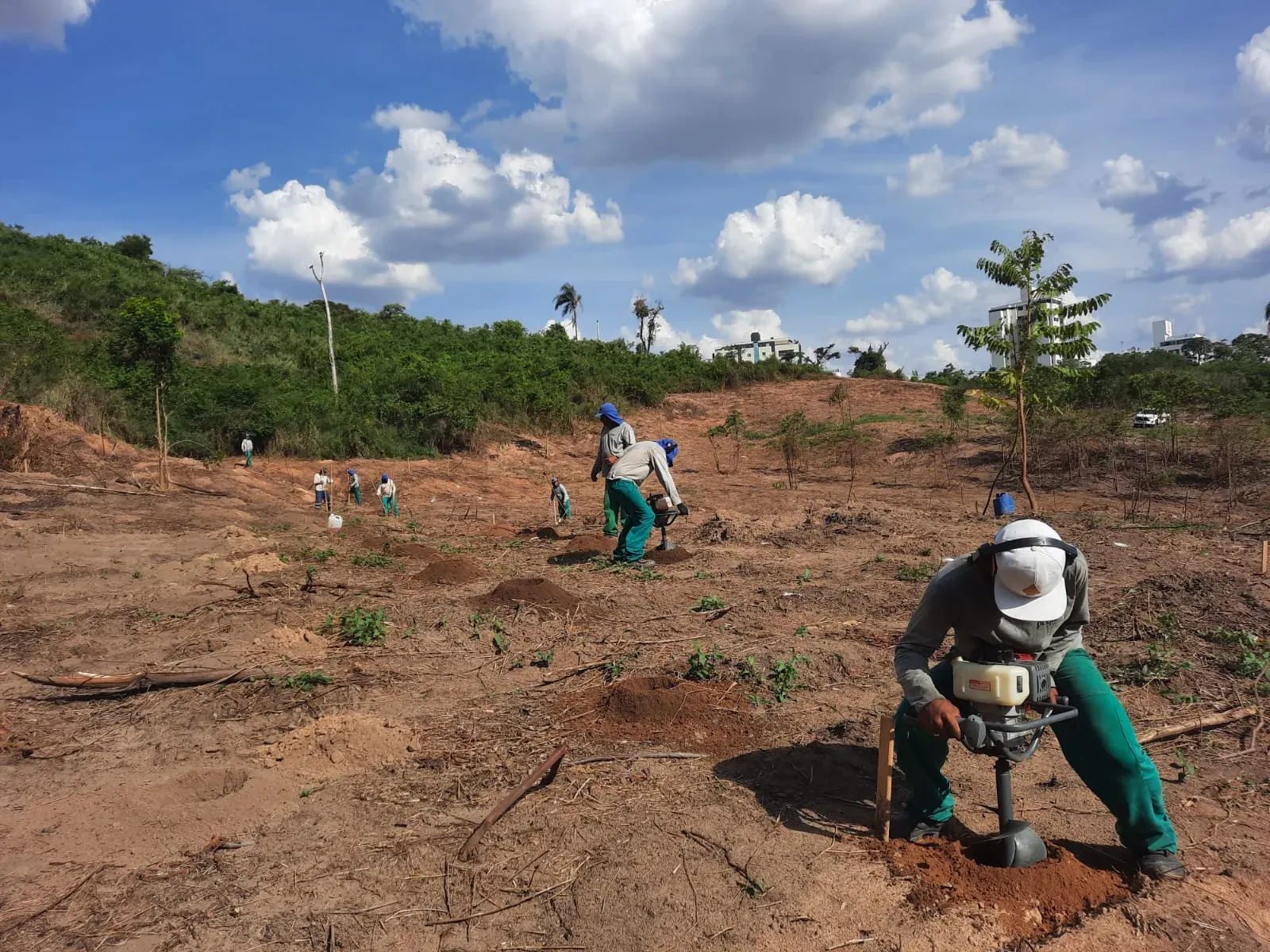 Equipe Pequi abrindo covas com perfurador motorizado para plantio das mudas