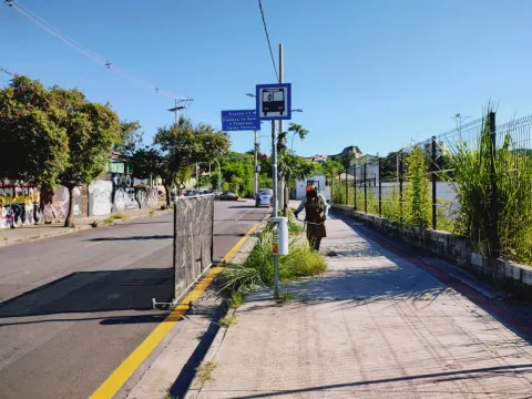 Colaborador da Pequi roçando vegetação em ciclovia urbana com roçadeira costal